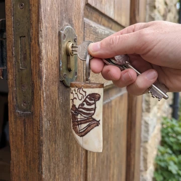 Zebra scrimshawed keychain made from wood and cow bone with curved edges